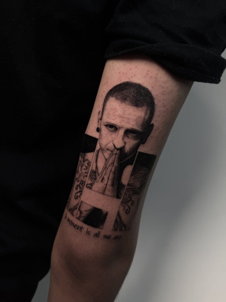 Realistic black and grey portrait tattoo of Chester Bennington with clasped hands and the phrase “A moment is all we are” — emotional tribute created at NOIR Tattoo Cusco, Peru.