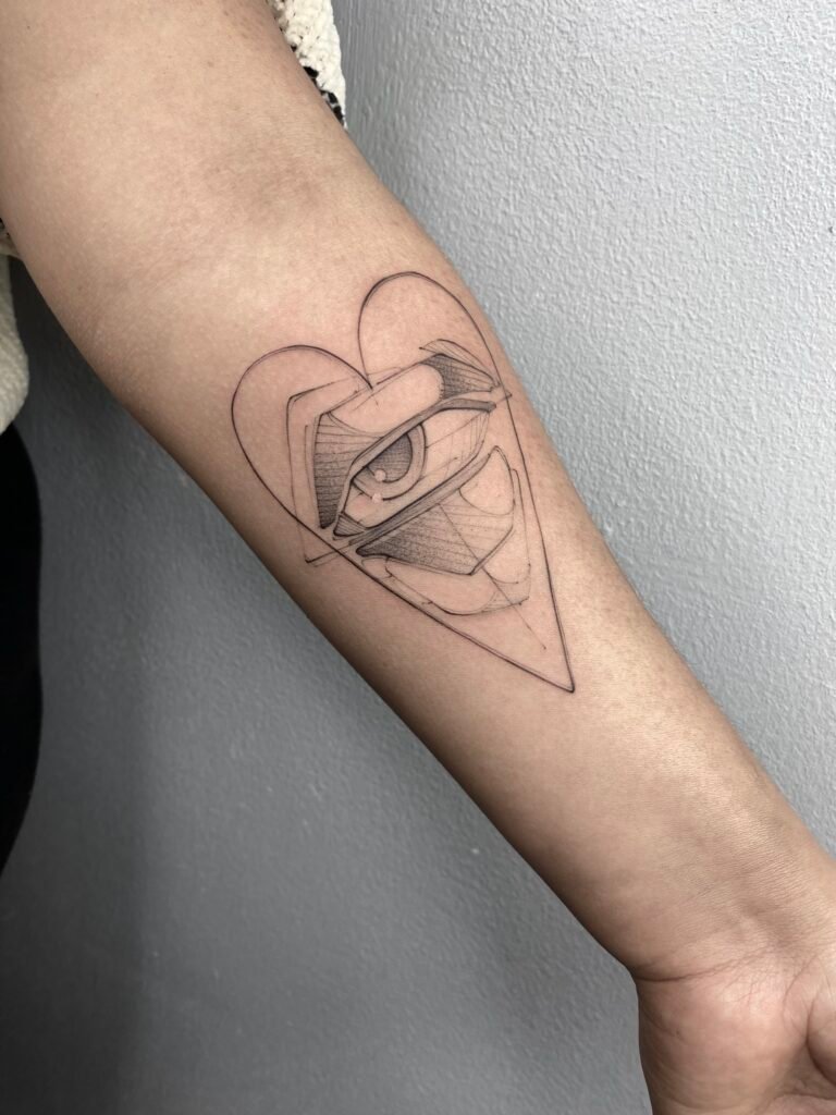 Fine line tattoo of an eye inside a heart, representing emotional awareness and inner vision. Delicate sketch-style design by NOIR Tattoo Cusco, Peru.