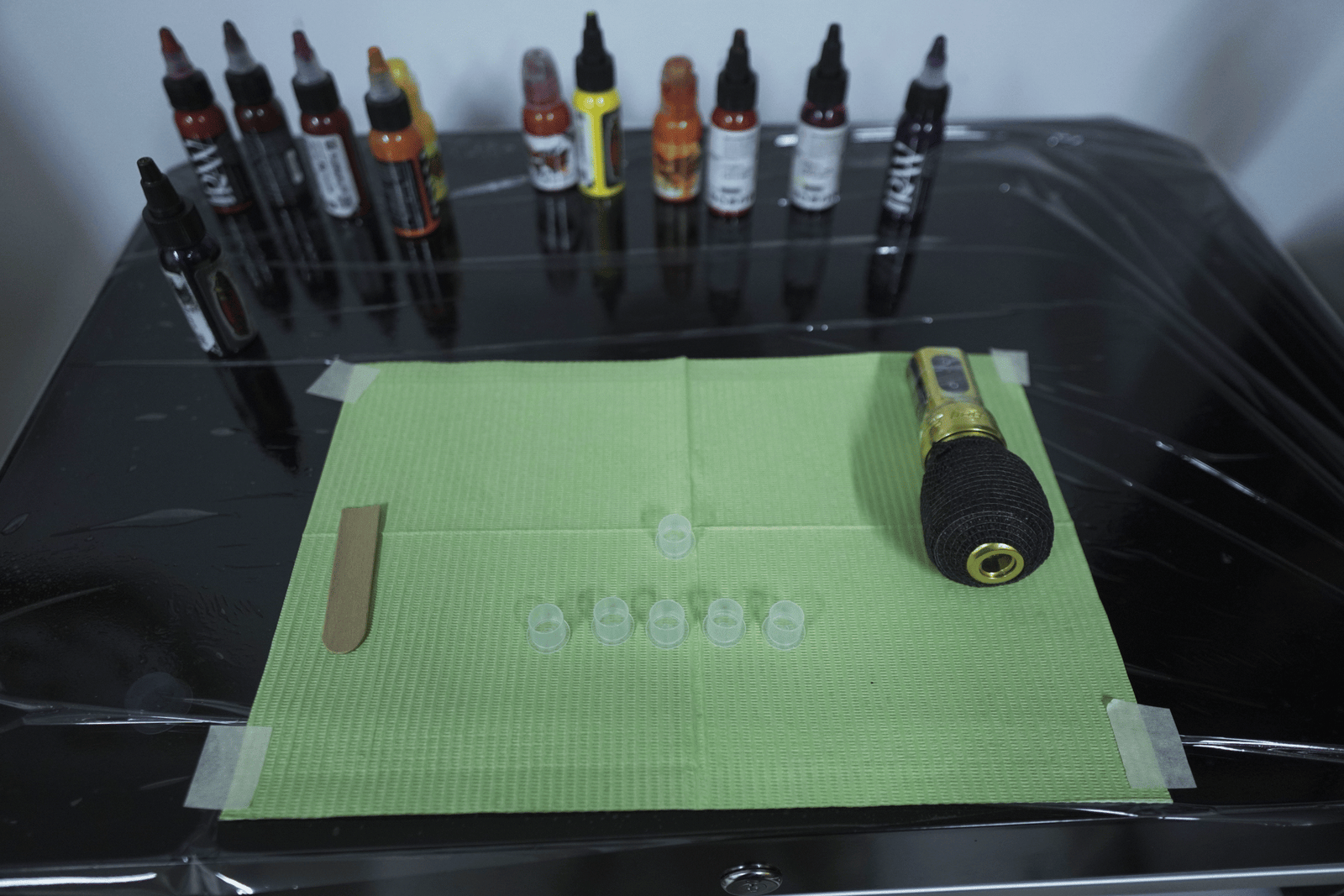 Tattoo ink setup on sterile workstation with organized ink caps and professional equipment prepared for tattooing at Noir Tattoo Cusco