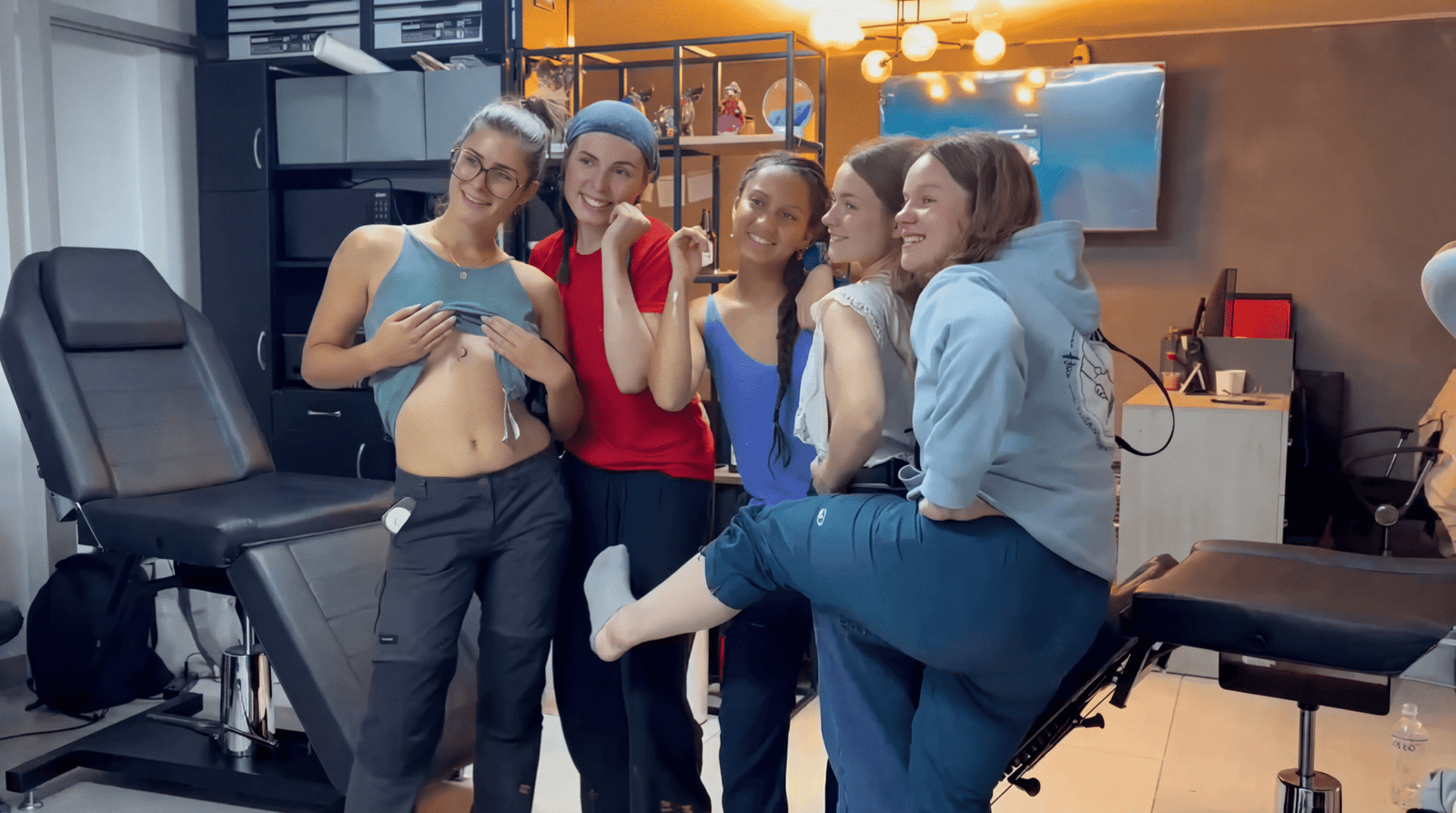 Group of friends showing fresh tattoos inside a professional tattoo studio in Cusco, Peru.