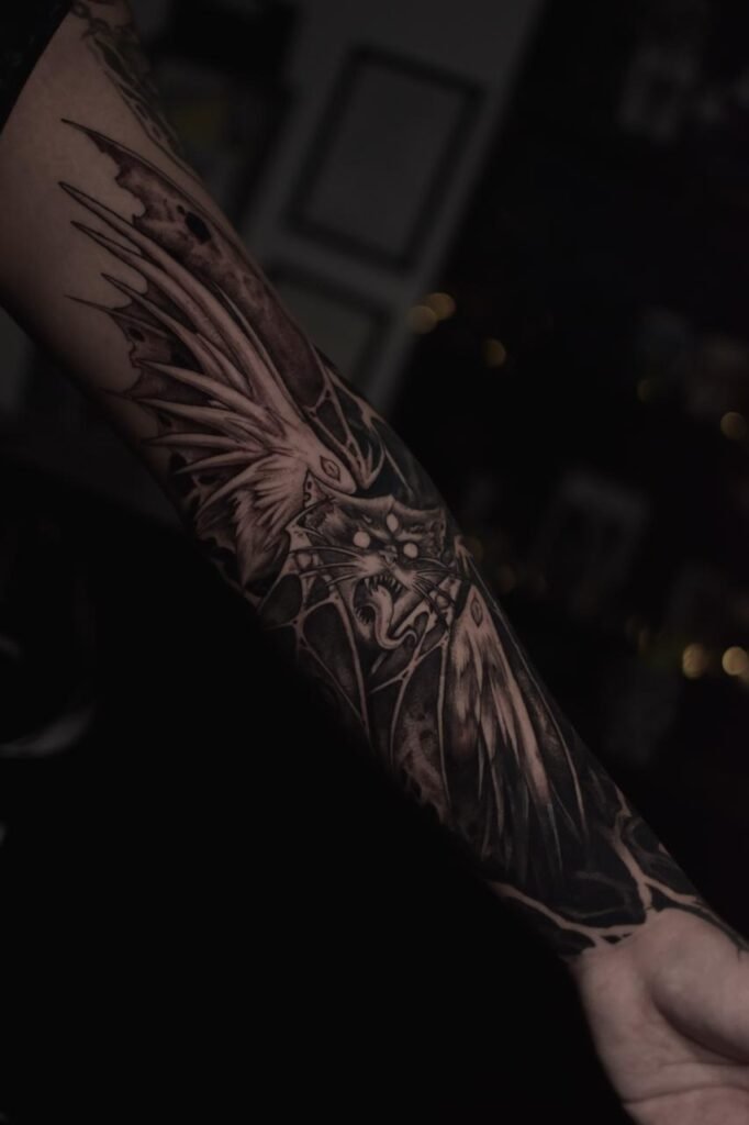 Dark blackwork bat tattoo on forearm created at NOIR Tattoo Cusco in Peru.