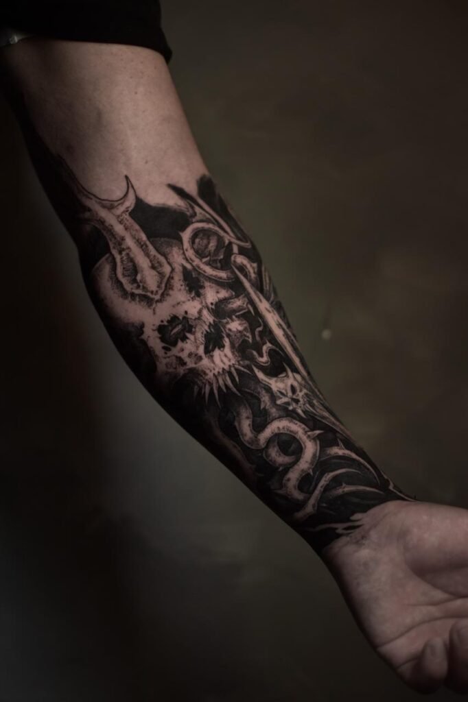 Dark blackwork skull tattoo on forearm created at NOIR Tattoo Cusco in Peru.