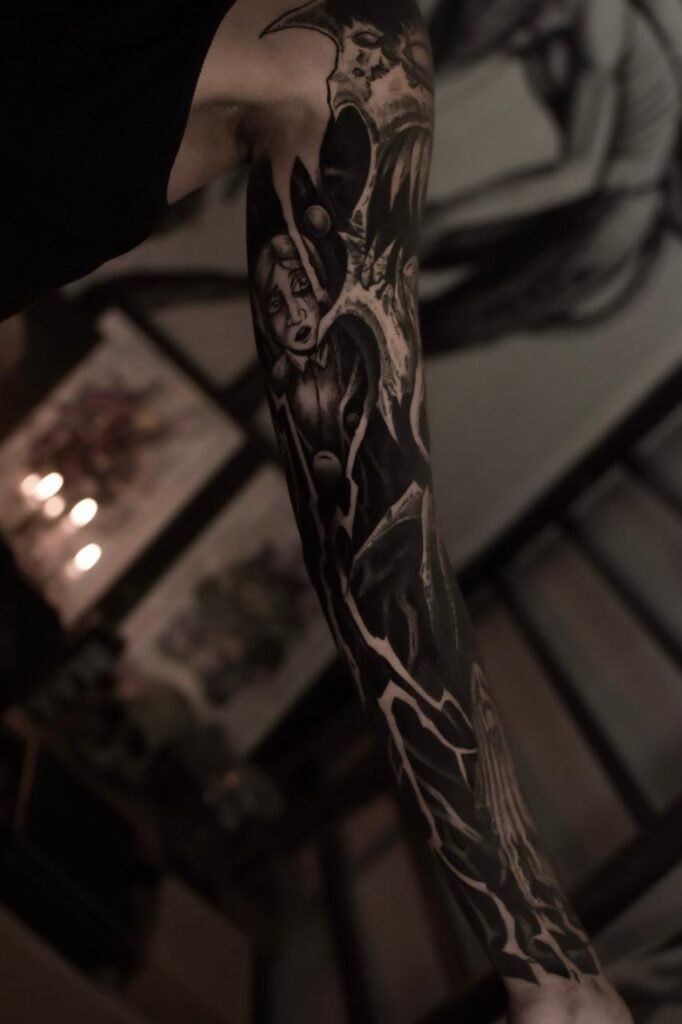 Dark blackwork sleeve tattoo with surreal gothic composition created at NOIR Tattoo Cusco in Peru.