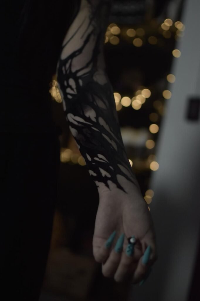 Dark ornamental blackwork forearm tattoo created at NOIR Tattoo Cusco in Peru.