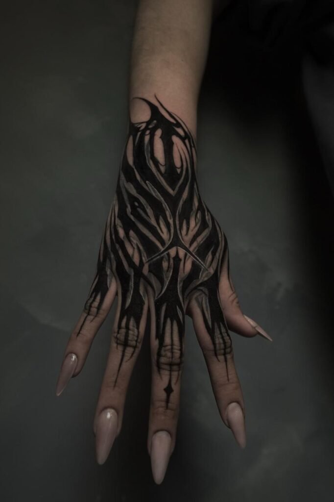Dark ornamental blackwork hand tattoo created at NOIR Tattoo Cusco in Peru.