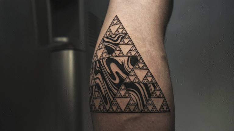 Geometric blackwork tattoo featuring a Sierpinski triangle fractal with abstract flowing patterns, created at Noir Tattoo Cusco, Peru.