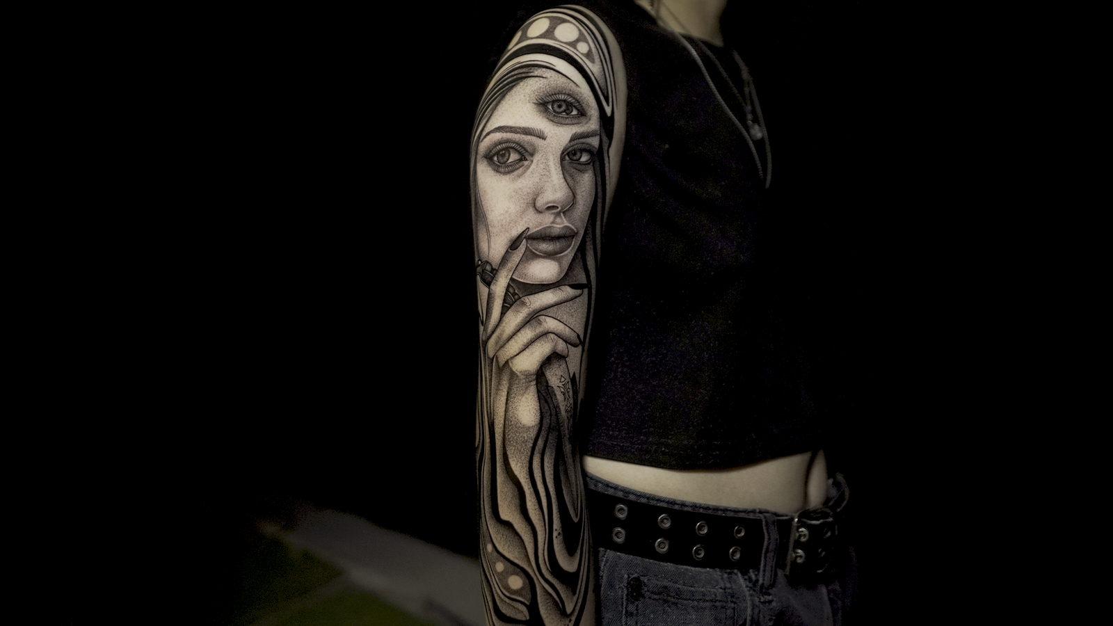 Surreal black and grey portrait tattoo featuring a woman with a third eye and abstract flowing elements, tattooed at Noir Tattoo Cusco, Peru.