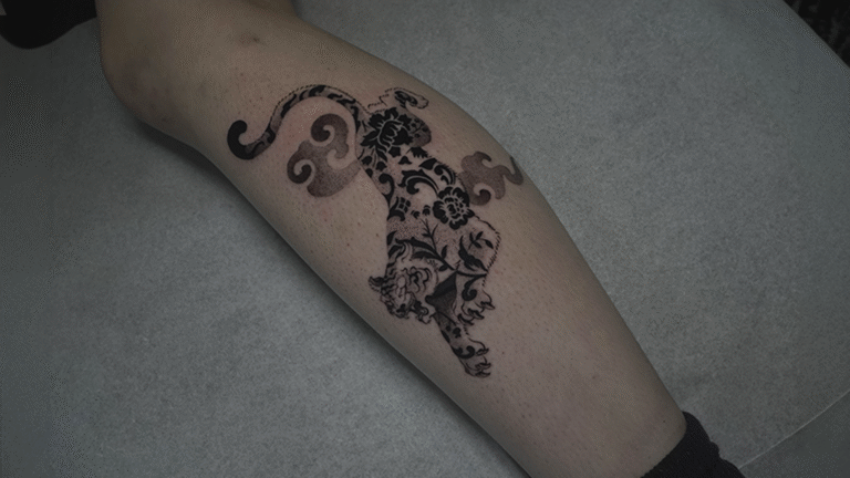 Ornamental Andean puma tattoo with floral blackwork design inspired by Inca symbolism, tattooed at Noir Tattoo Cusco, Peru.