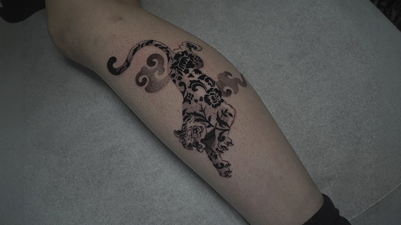 Ornamental Andean puma tattoo with floral blackwork design inspired by Inca symbolism, tattooed at Noir Tattoo Cusco, Peru.