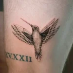 Black and grey hummingbird tattoo in flight with open wings at Noir Tattoo Cusco