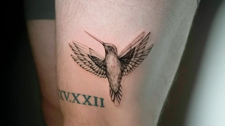 Black and grey hummingbird tattoo in flight with open wings at Noir Tattoo Cusco