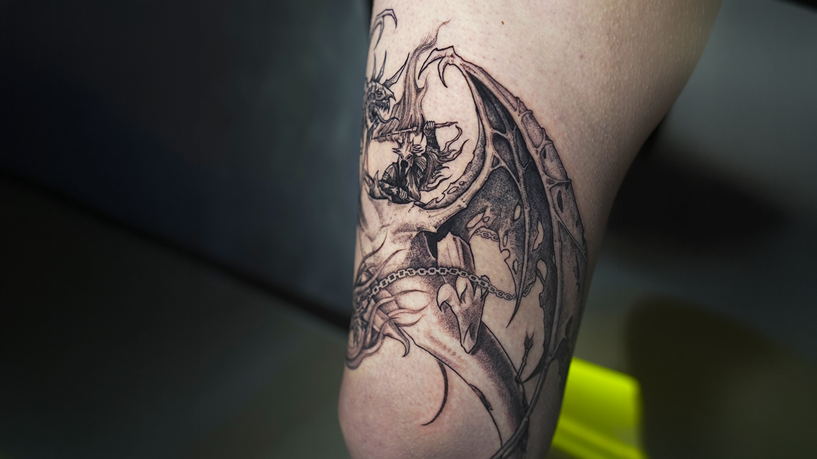 Dark fantasy dragon tattoo in black and grey featuring gothic details, demonic wings, and intricate linework, tattooed at Noir Tattoo Cusco, Peru.