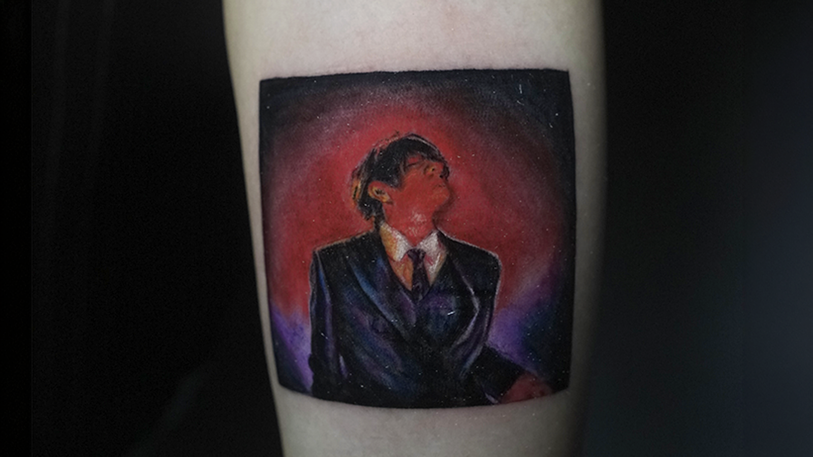 Color realism tattoo inspired by a music album cover featuring a dramatic portrait with cinematic lighting, tattooed at Noir Tattoo Cusco, Peru.