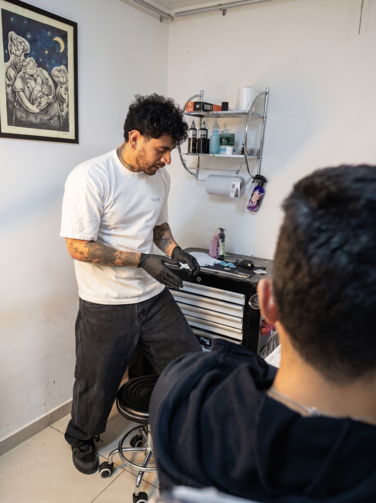 Professional tattoo artist preparing a client at Noir Tattoo studio in Cusco, Peru